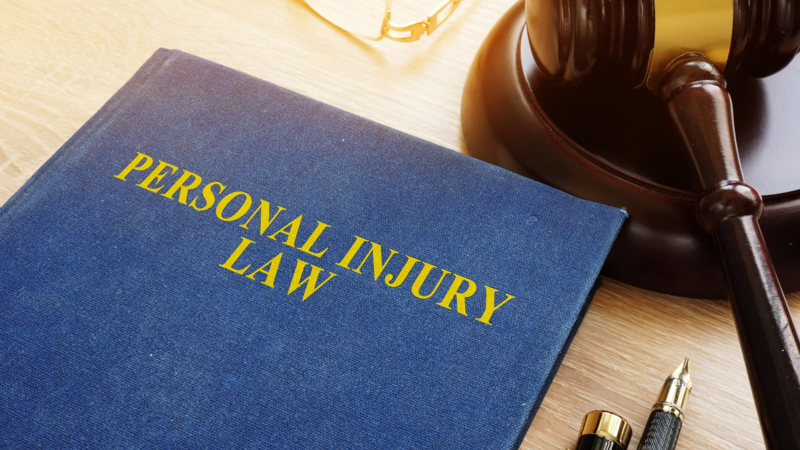 Personal Injury Lawyer - Personal injury law on a desk and gavel.